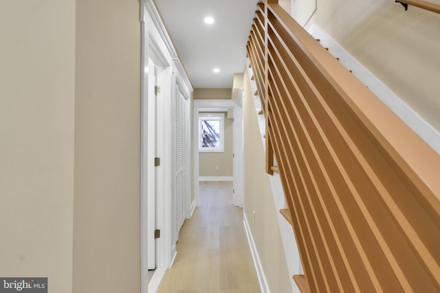 hallway featuring baseboards, light wood-style floors, and recessed lighting