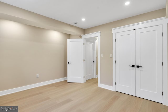 unfurnished bedroom featuring light wood-type flooring, recessed lighting, baseboards, and a closet