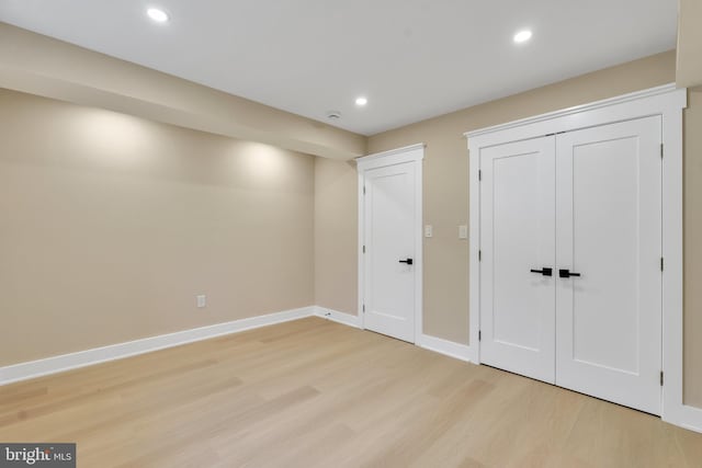 unfurnished bedroom featuring light wood-style flooring, baseboards, recessed lighting, and a closet