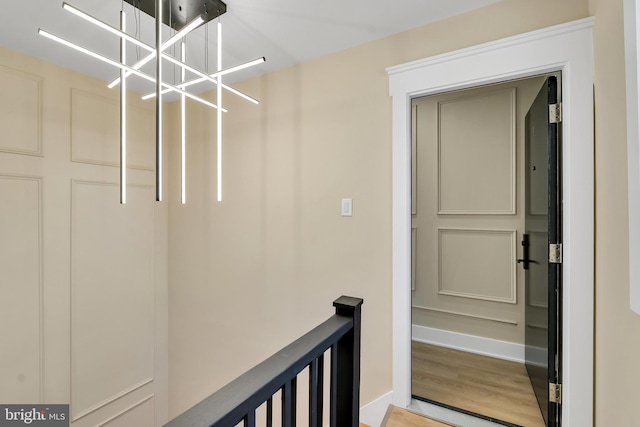 mudroom featuring light wood-style floors, a chandelier, and baseboards