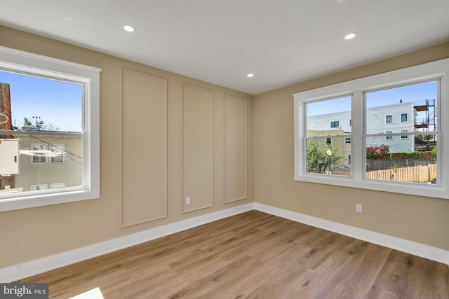 unfurnished room featuring baseboards, light wood-style floors, and recessed lighting