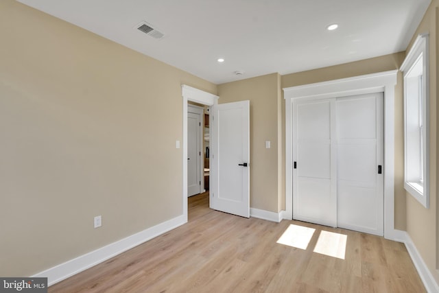 unfurnished bedroom with light wood-style floors, baseboards, a closet, and recessed lighting