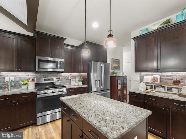 20 Parker Dr, Millsboro, DE 19966 - kitchen featuring appliances with stainless steel finishes, backsplash, a kitchen island, dark brown cabinets, and light stone counters