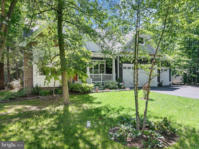 20 Parker Dr, Millsboro, DE 19966 - obstructed view of property with asphalt driveway, covered porch, a garage, and a front yard