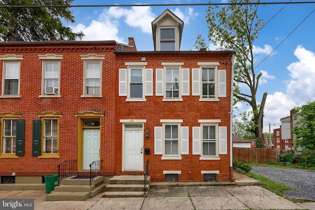 view of front of house with brick siding and fence