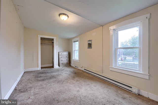 unfurnished bedroom featuring carpet, baseboard heating, a closet, and baseboards