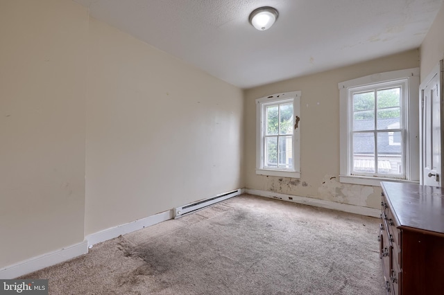 carpeted spare room with baseboard heating and baseboards