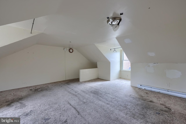 additional living space with a baseboard heating unit, lofted ceiling, and carpet