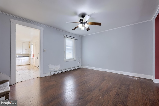 spare room featuring a baseboard heating unit, a ceiling fan, crown molding, wood finished floors, and baseboards