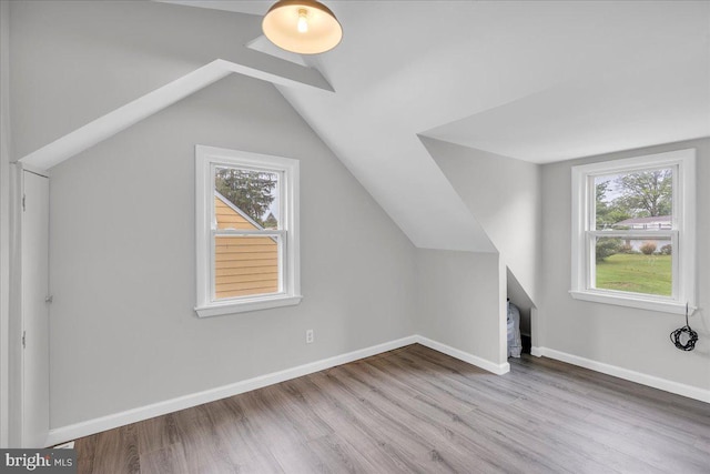 bonus room featuring wood finished floors, lofted ceiling, and baseboards