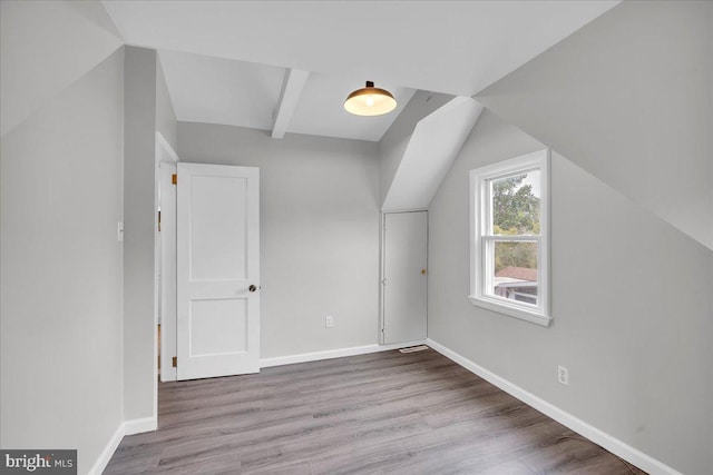 additional living space featuring wood finished floors and baseboards