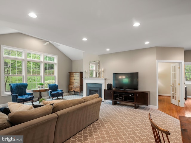 living room featuring plenty of natural light, recessed lighting, a glass covered fireplace, ceiling fan, and lofted ceiling