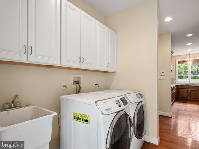 laundry area featuring cabinet space, wood finished floors, recessed lighting, washer and clothes dryer, and baseboards