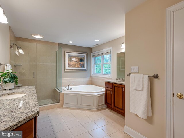 full bath with tile patterned flooring, a shower stall, two vanities, a garden tub, and recessed lighting