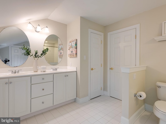 bathroom featuring toilet, tile patterned floors, double vanity, baseboards, and lofted ceiling