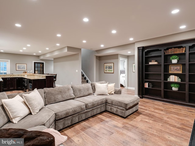 living room with light wood finished floors, stairs, and recessed lighting