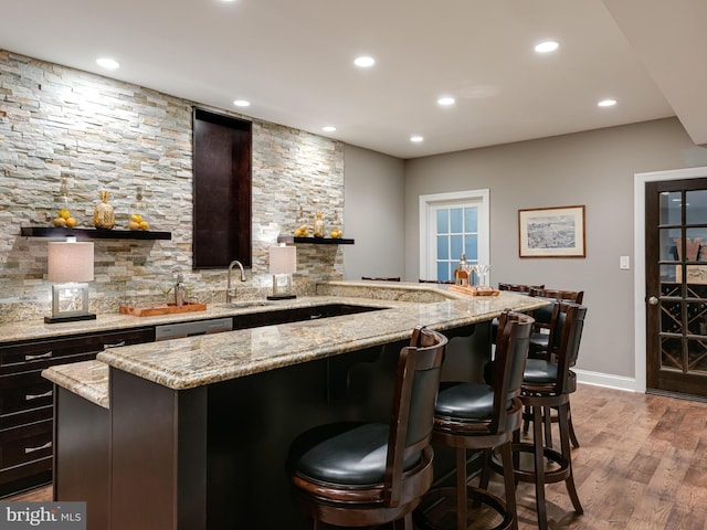 indoor wet bar with recessed lighting, light wood-style floors, baseboards, and dishwasher