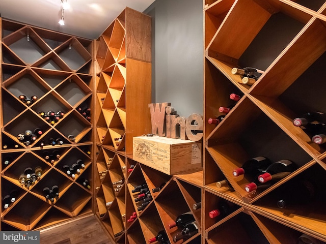 wine cellar with wood finished floors and rail lighting