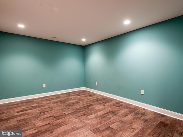 spare room with wood finished floors, baseboards, and recessed lighting