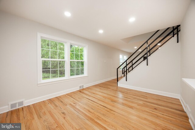 unfurnished living room with stairs, recessed lighting, wood finished floors, and baseboards