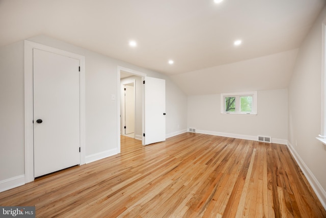 additional living space featuring light wood-style flooring, lofted ceiling, baseboards, and recessed lighting