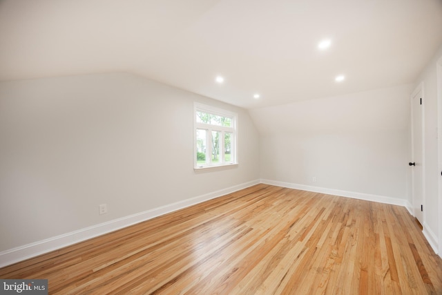 additional living space with lofted ceiling, light wood-style floors, baseboards, and recessed lighting