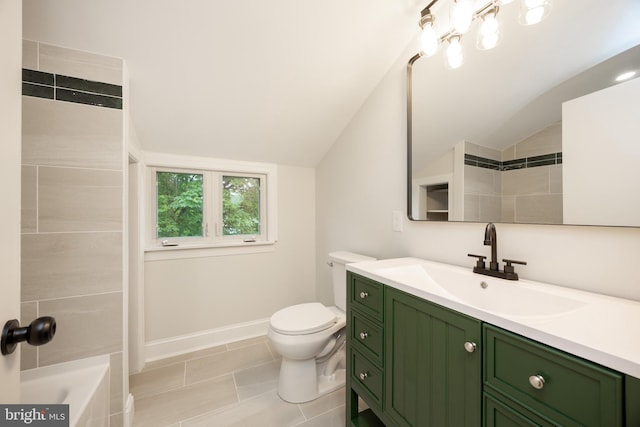 full bathroom with lofted ceiling, vanity, toilet, a tub, and baseboards