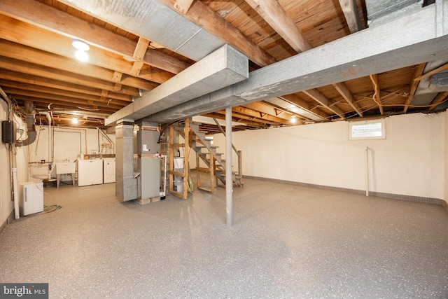 basement featuring washing machine and clothes dryer, stairs, a sink, and baseboards