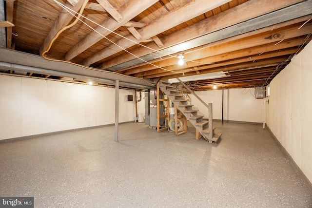 unfinished basement featuring stairway, baseboards, and heating unit