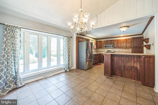 147 Heather Rd, Haddon Township, NJ 08107 - kitchen featuring appliances with stainless steel finishes, decorative backsplash, a chandelier, and healthy amount of natural light