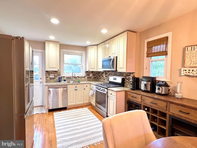 10021 Lorain Ave, Silver Spring, MD 20901 - kitchen with stainless steel appliances, a sink, tasteful backsplash, light wood-type flooring, and light stone counters