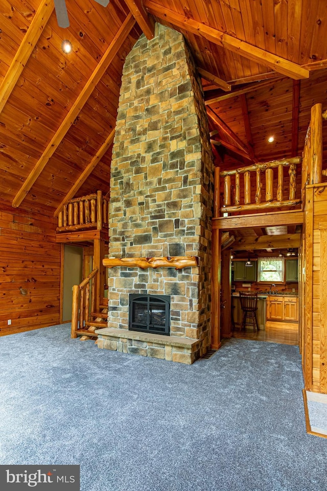 821 Sand Ridge Rd, Howard, PA 16841 - unfurnished living room featuring wooden ceiling, carpet, beamed ceiling, a stone fireplace, and wooden walls