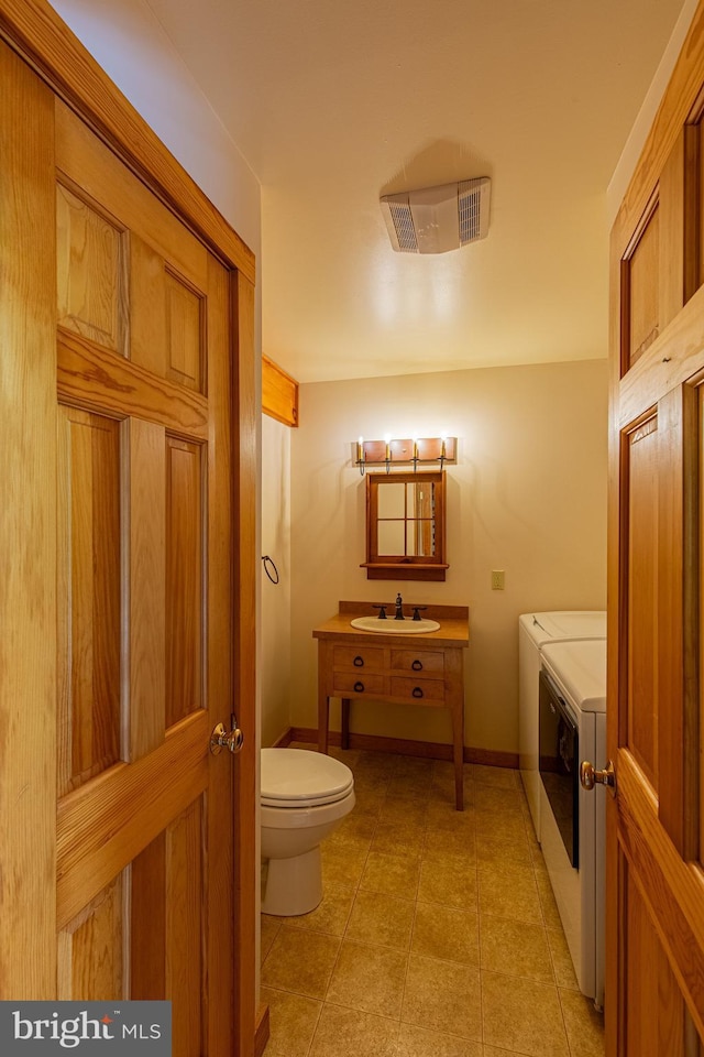 821 Sand Ridge Rd, Howard, PA 16841 - half bathroom featuring washing machine and dryer, toilet, baseboards, tile patterned flooring, and vanity