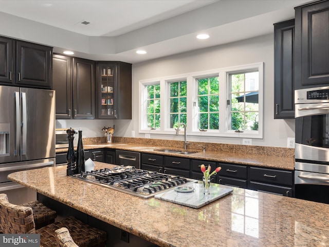 12906 Brafferton Ct, Herndon, VA 20171 - kitchen with a sink, stainless steel appliances, a breakfast bar area, glass insert cabinets, and light stone counters