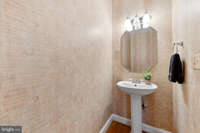 bathroom with baseboards and wood finished floors