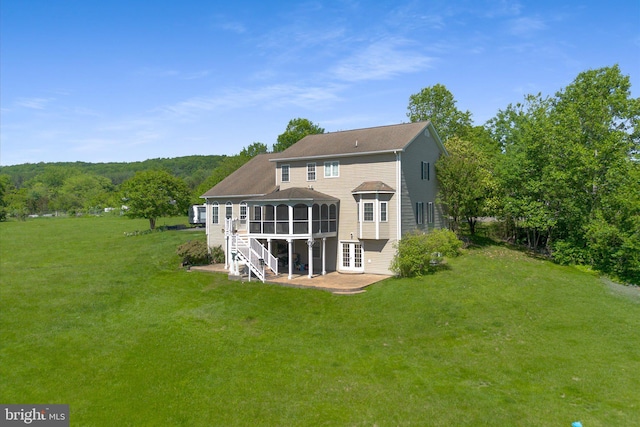 rear view of house with a patio area, a yard, a sunroom, and french doors