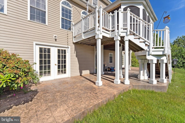 rear view of house with a patio, stairs, a deck, french doors, and a lawn