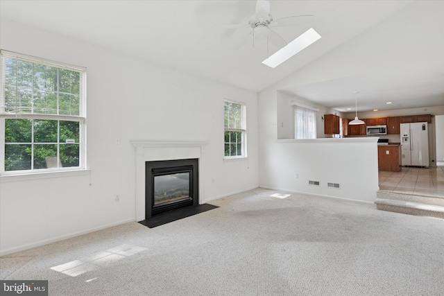 7 Gazelle Pl, New Castle, DE 19720 - unfurnished living room featuring a ceiling fan, light carpet, a fireplace with flush hearth, a skylight, and baseboards