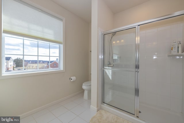 full bathroom featuring a shower stall, tile patterned flooring, toilet, and baseboards