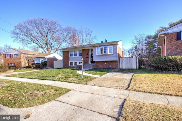 split foyer home featuring brick siding and a gate