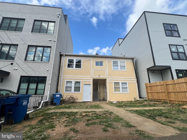 rear view of house featuring fence