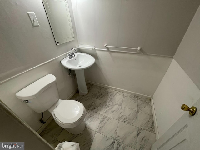 3208 28th Pkwy, Temple Hills, MD 20748 - bathroom with marble look tiles, toilet, baseboards, and a sink