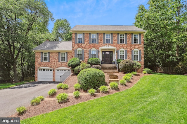 11476 Bronzedale Dr, Oakton, VA 22124 - colonial inspired home featuring asphalt driveway, a garage, brick siding, and a shingled roof