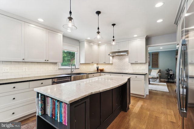 11476 Bronzedale Dr, Oakton, VA 22124 - kitchen with a sink, under cabinet range hood, white cabinets, light wood-type flooring, and decorative backsplash