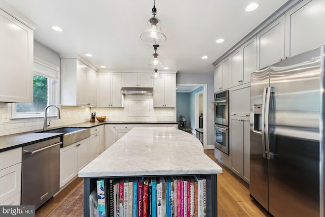 11476 Bronzedale Dr, Oakton, VA 22124 - kitchen with appliances with stainless steel finishes, a sink, wood finished floors, decorative backsplash, and recessed lighting