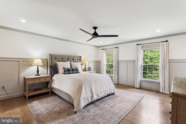 11476 Bronzedale Dr, Oakton, VA 22124 - bedroom featuring a decorative wall, ornamental molding, a wainscoted wall, wood finished floors, and a ceiling fan