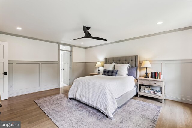 11476 Bronzedale Dr, Oakton, VA 22124 - bedroom featuring a decorative wall, crown molding, a wainscoted wall, wood finished floors, and a ceiling fan