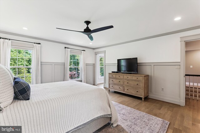 11476 Bronzedale Dr, Oakton, VA 22124 - bedroom featuring multiple windows, a decorative wall, a wainscoted wall, wood finished floors, and crown molding