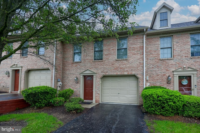 townhome / multi-family property with driveway and brick siding