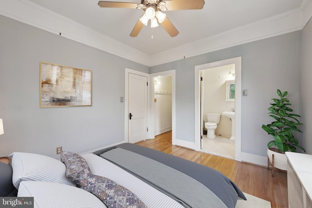 bedroom with light wood-style flooring, baseboards, connected bathroom, crown molding, and a ceiling fan